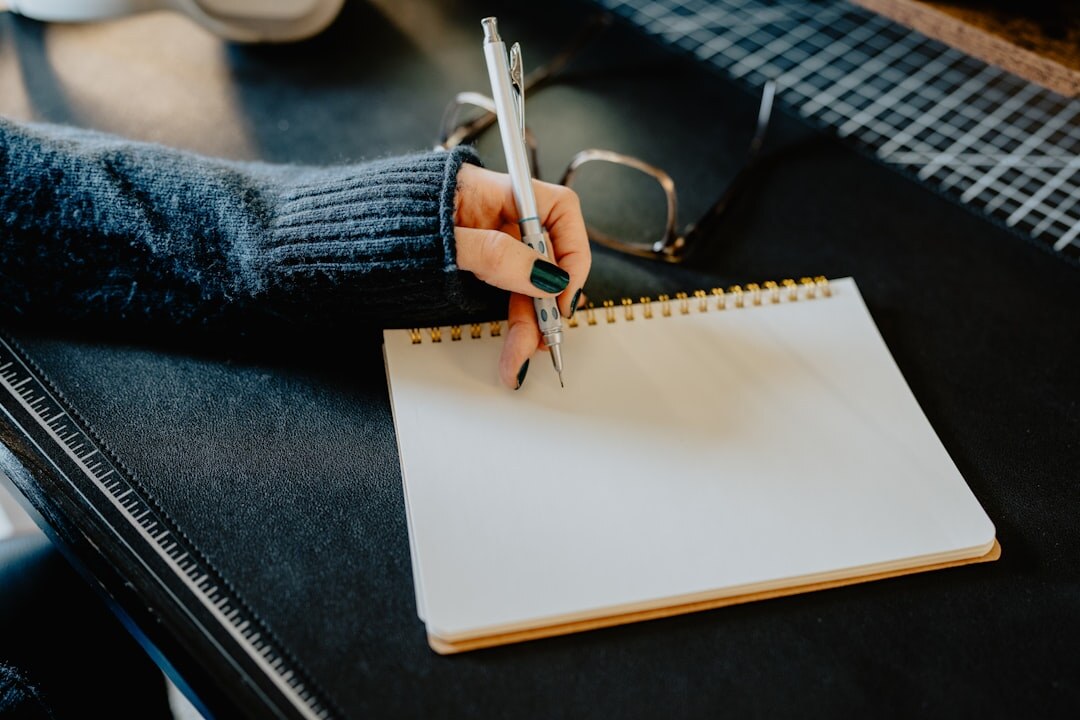 person writing goals in notebook